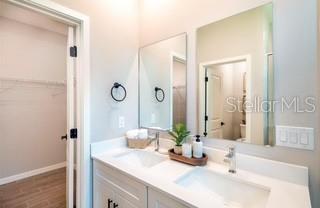 A bathroom features a white vanity with a double sink, mirrors, and an adjacent closet — 3859 SW 169TH PLACE, OCALA, FL