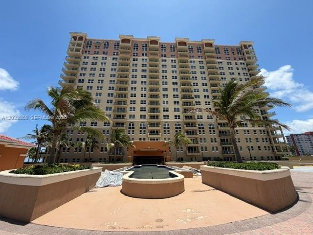 A tall, multi-story residential building features numerous balconies and palm trees in the foreground — 2080 S Ocean Dr # 1512, Hallandale Beach FL 33009, HALLANDALE BEACH, FL