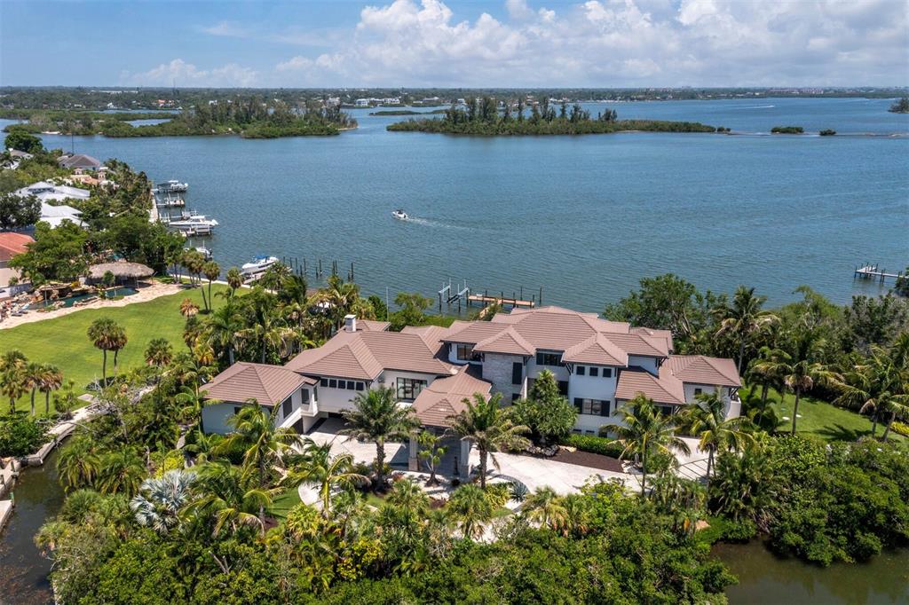 A modern luxury home features a large infinity pool with a stone-tiled edge and patio — 3799 FLAMINGO AVENUE, SARASOTA, FL