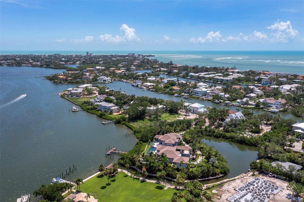 A sunken fire pit lounge sits within an infinity pool overlooking a body of water — 3799 FLAMINGO AVENUE, SARASOTA, FL