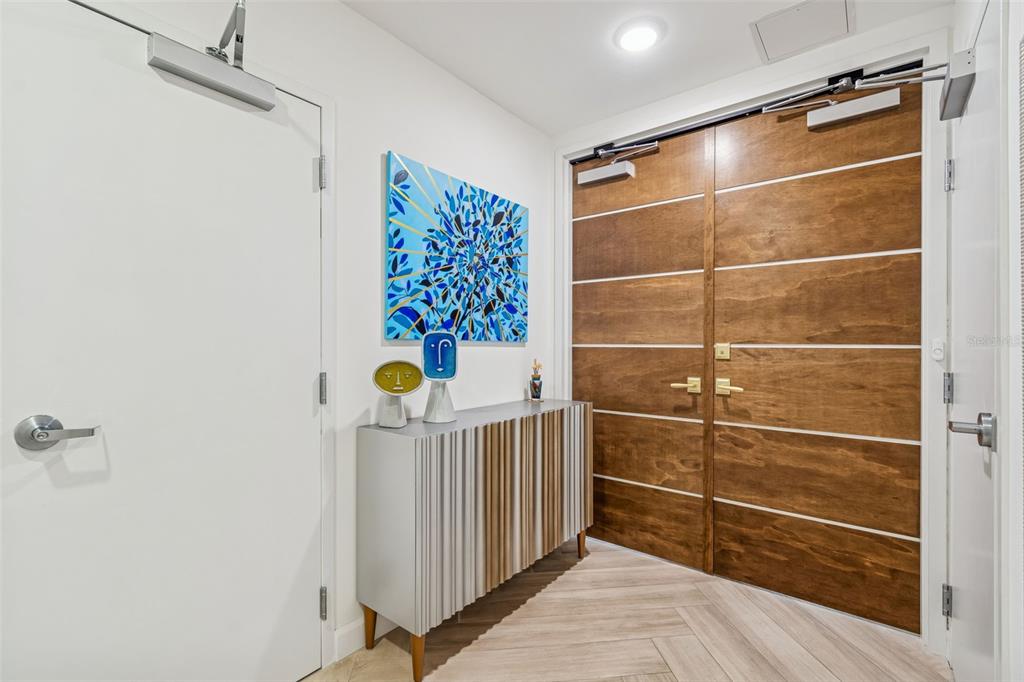 An entryway features a wood-paneled double door, a white door, and a modern console table — 2900 W BAY TO BAY BOULEVARD UNIT 501, TAMPA, FL