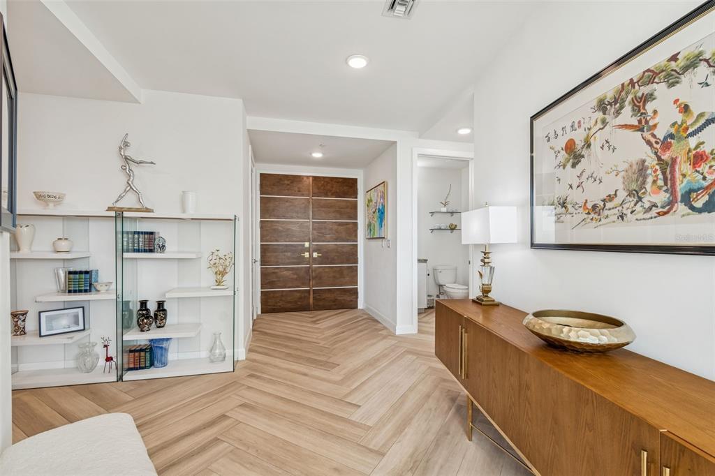 An entryway features herringbone wood floors, a double wood door, and a wooden console table — 2900 W BAY TO BAY BOULEVARD UNIT 501, TAMPA, FL