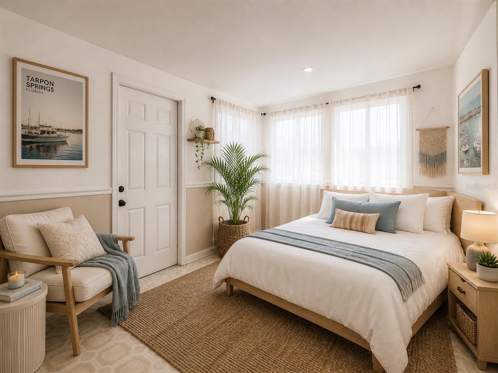 A bedroom features a bed, an armchair, a potted plant, and a door — 531 ATHENS STREET, TARPON SPRINGS, FL