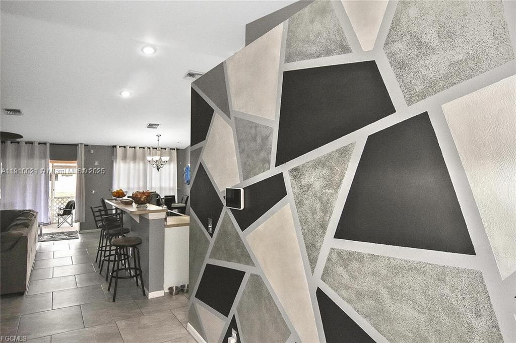 A living area features a geometric accent wall with gray, black, and white panels — 2612 66 st w, Lehigh Acres FL 33971, LEHIGH ACRES, FL