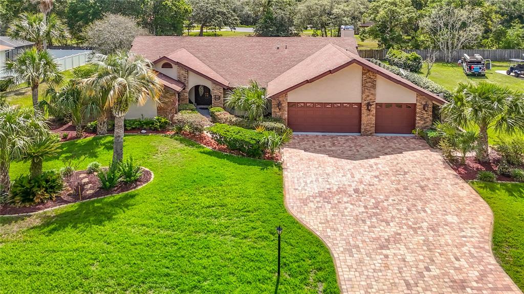 An aerial view of a single-story house with a brick driveway and palm trees — 4306 RIVER BIRCH DRIVE, SPRING HILL, FL