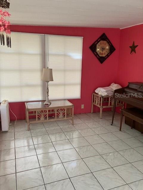 A room with pink walls, white tile floors, a rattan coffee table, and a piano — 3350 COURTNEY DRIVE, HOLIDAY, FL