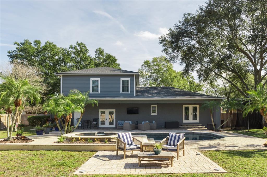 A two-story house with a backyard pool, patio furniture, and a paved seating area — 8445 SHADY GLEN DRIVE, ORLANDO, FL