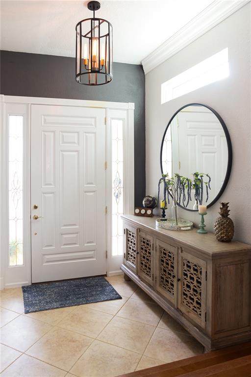 An entryway features a white front door, a wooden console table, and a round wall mirror — 8445 SHADY GLEN DRIVE, ORLANDO, FL