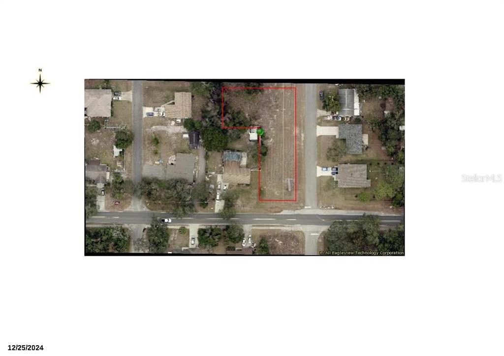 An aerial view shows a rectangular lot outlined in red situated between two paved roads — 380 WILLIAMS AVENUE, ORANGE CITY, FL