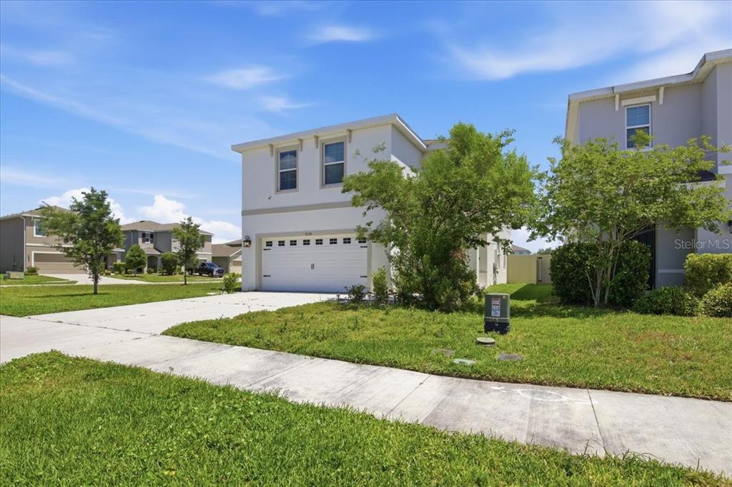 A two-story suburban house with a white exterior, a two-car garage, and a front lawn — 3126 SUNCOAST BLEND DRIVE, ODESSA, FL