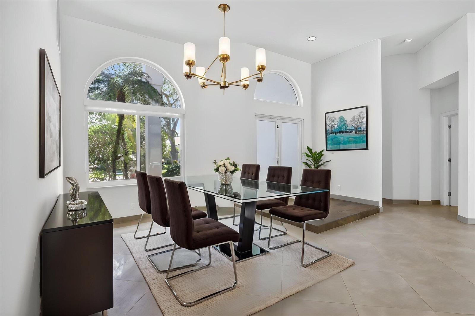 A dining room features a glass-topped table, six brown chairs, and a gold chandelier — 2647 Miller Court, Weston FL 33332, WESTON, FL