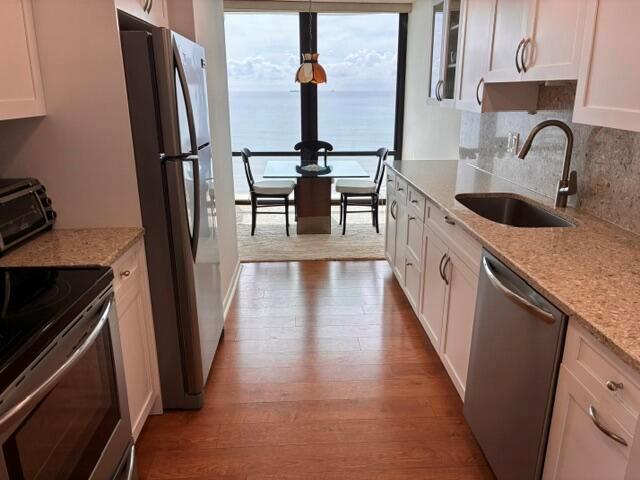 A galley kitchen with white cabinets and granite countertops leads to a dining area overlooking ocean — 250 S Ocean Boulevard # 3h, Boca Raton FL 33432, BOCA RATON, FL