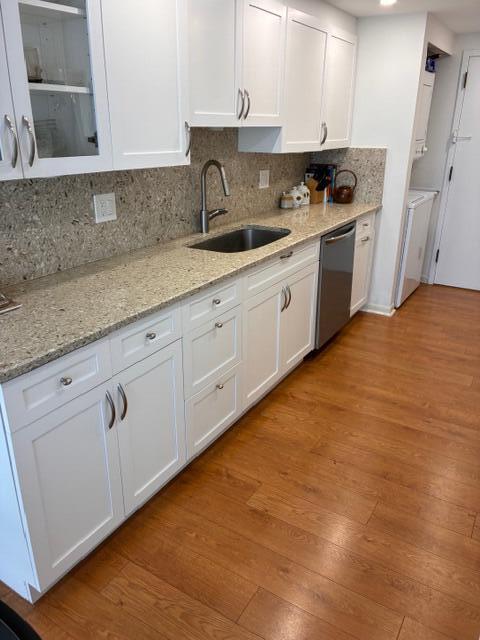 A kitchen features white cabinets, granite countertops, a stainless steel sink, and wood-look flooring — 250 S Ocean Boulevard # 3h, Boca Raton FL 33432, BOCA RATON, FL