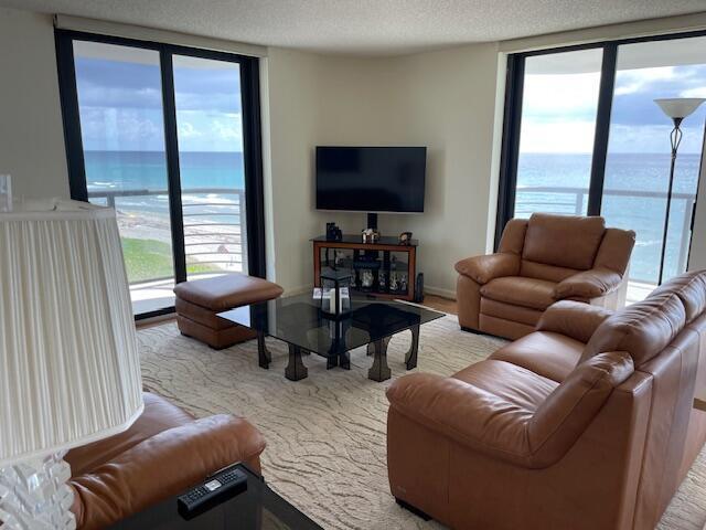 A living room with leather furniture, a glass coffee table, and ocean views through windows — 250 S Ocean Boulevard # 3h, Boca Raton FL 33432, BOCA RATON, FL