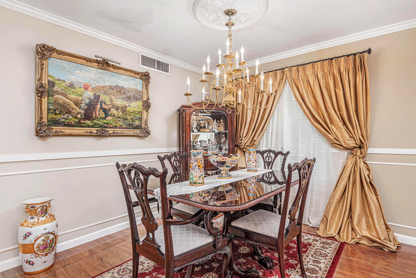 A formal dining room features a glass-topped table, ornate chairs, a chandelier, and wall art — 18560 SE Wood Haven Lane # G, Jupiter FL 33469, JUPITER, FL
