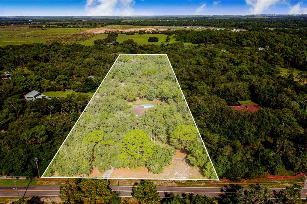 An aerial view shows a large, wooded residential lot outlined in white along a road — 10740 JIM EDWARDS ROAD, HAINES CITY, FL