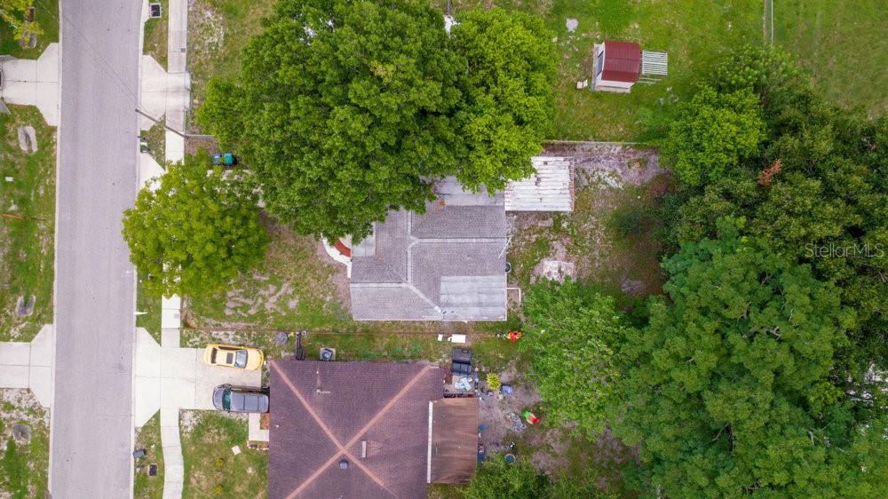 An aerial view shows two houses with shingled roofs, surrounding trees, and a small shed — 7524 MARIETTA STREET, ORLANDO, FL
