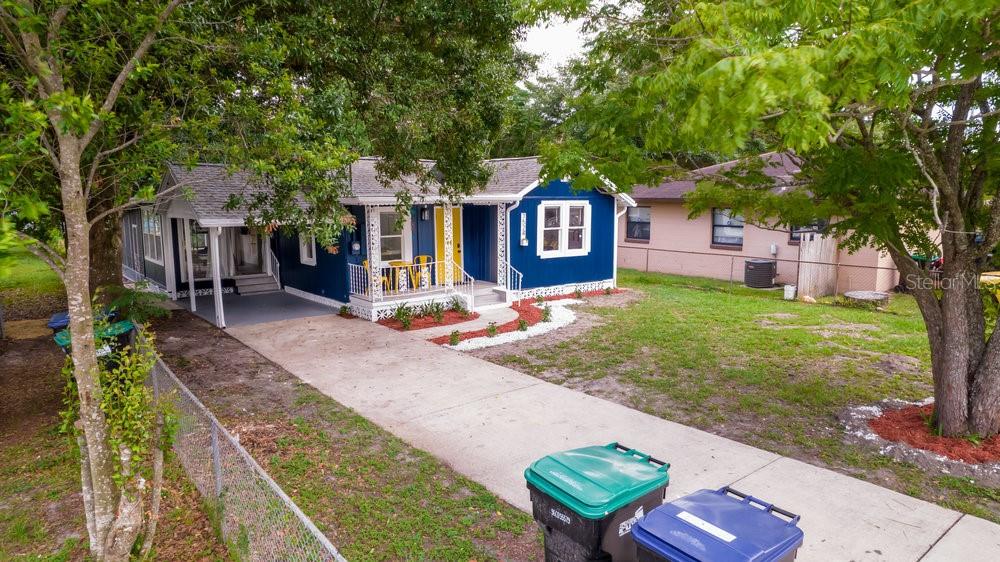A blue house with a yellow front door, a carport, and a concrete driveway — 7524 MARIETTA STREET, ORLANDO, FL