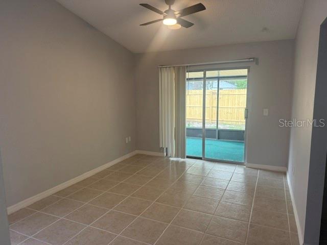 A room with light-colored tile flooring, a ceiling fan, and sliding glass doors to a patio — 5301 PINEBURY COURT, ORLANDO, FL