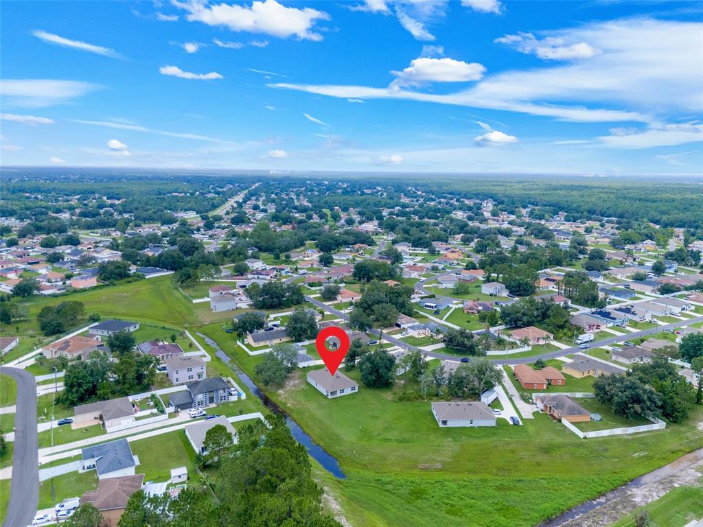An aerial view shows a single-story house with a red location pin in a neighborhood — 658 COTULLA DRIVE, KISSIMMEE, FL
