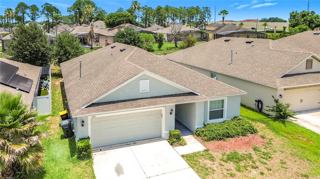 An aerial view of a single-story suburban house with a two-car garage and driveway — 225 BELLA VERANO WAY, DAVENPORT, FL