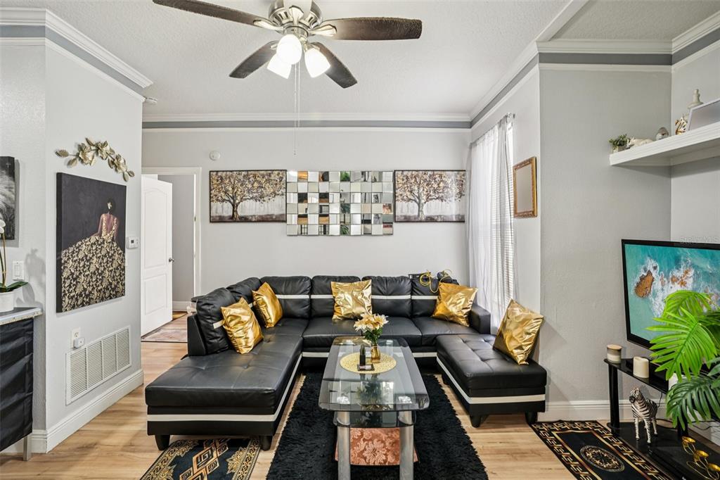 A living room features a black sectional sofa, a glass coffee table, and gold accents — 10505 VILLA VIEW CIRCLE, TAMPA, FL
