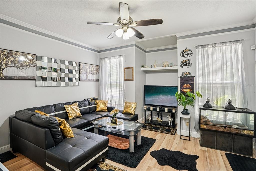 A living room features a black sectional sofa, a glass coffee table, and a television — 10505 VILLA VIEW CIRCLE, TAMPA, FL
