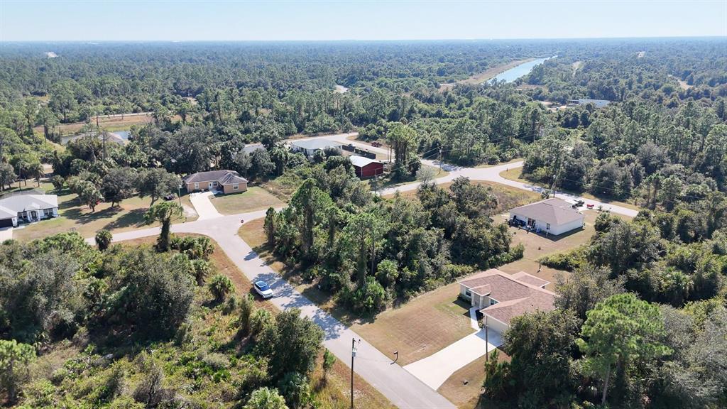 An aerial view shows several houses situated among dense trees and winding paved roads — FIELDING STREET, NORTH PORT, FL