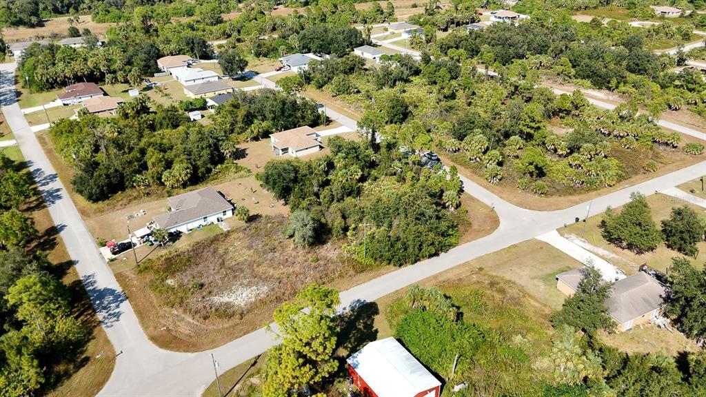 An aerial view shows several houses surrounded by dense trees and vegetation along paved roads — FIELDING STREET, NORTH PORT, FL
