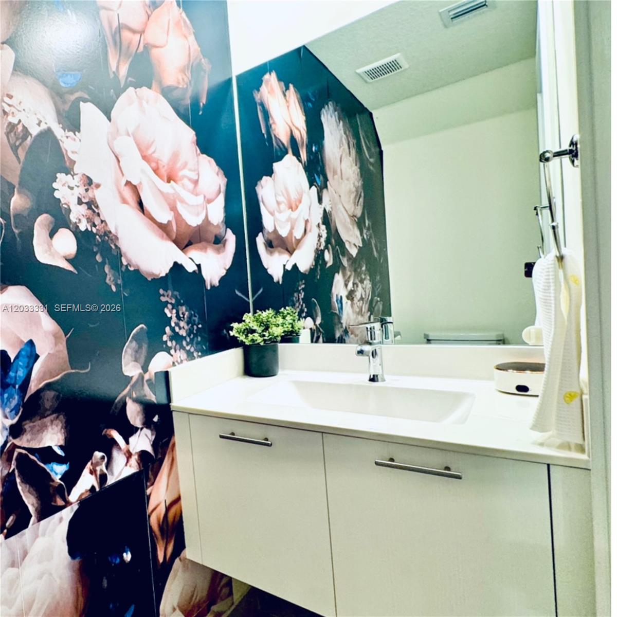 A bathroom features a white vanity, a large mirror, and dark floral wallpaper — 10295 NW 64th Ter # 104, Doral FL 33178, DORAL, FL