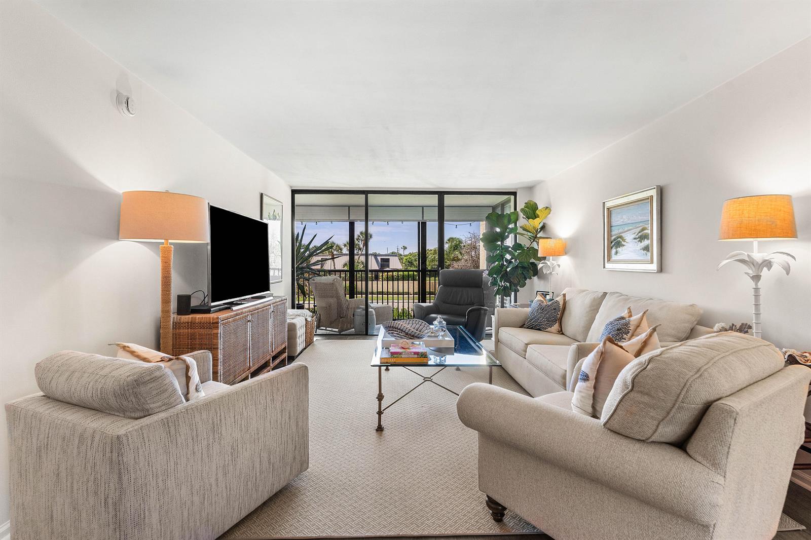 A living room features a beige sofa, two armchairs, a glass coffee table, and balcony access — 1605 S Us Highway 1, Jupiter FL 33477, JUPITER, FL