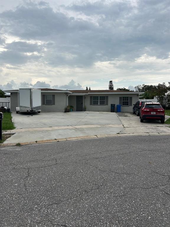 A single-story house with a large concrete driveway, a trailer, and a red SUV — 6503 DOVEWOOD PLACE, TAMPA, FL
