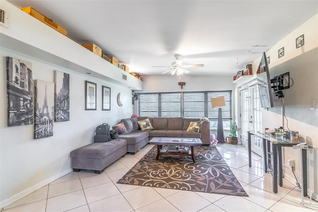 A living room features a gray sectional sofa, a coffee table, and tiled flooring — 743 ALFRED DRIVE, ORLANDO, FL