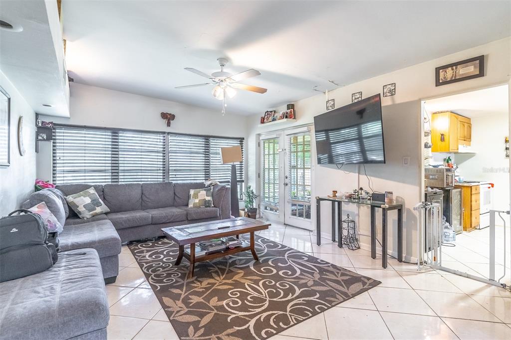 A living room with a gray sectional sofa, a patterned rug, and a wall-mounted television — 743 ALFRED DRIVE, ORLANDO, FL