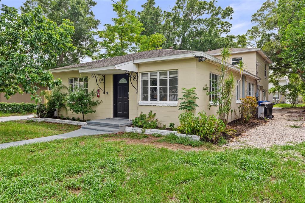 A single-story tan house with a black front door and a gravel driveway — 4222 18TH STREET N, ST PETERSBURG, FL