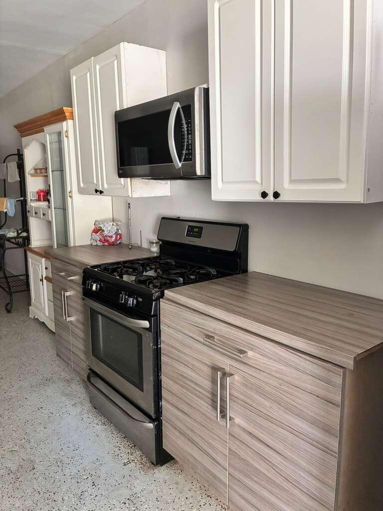 A kitchen with light-colored cabinets, a hutch, stainless steel appliances, and a speckled floor — 9024 Apache Boulevard # A, Loxahatchee FL 33470, LOXAHATCHEE, FL