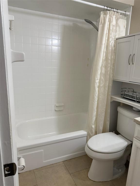 A bathroom features a white bathtub with tiled walls, a toilet, and a storage cabinet — 1419 DAVIDSON STREET, ORLANDO, FL