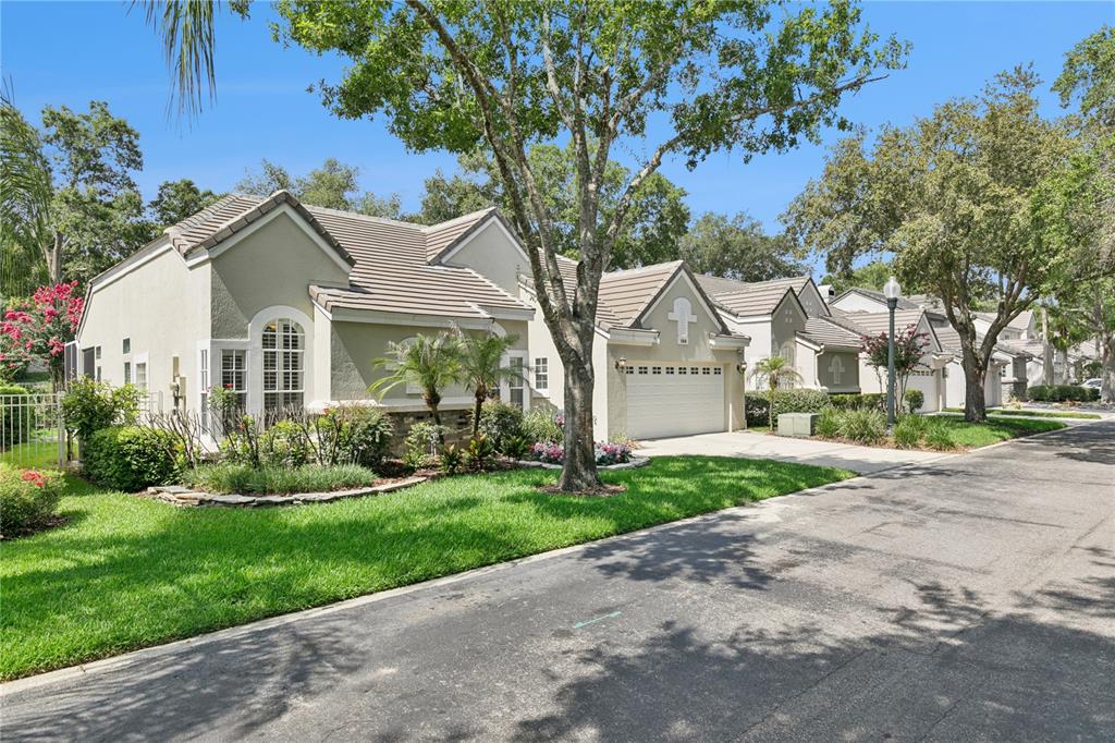 A single-story house with a beige stucco exterior, a tiled roof, and a two-car garage — 184 WIMBLEDON CIRCLE, LAKE MARY, FL