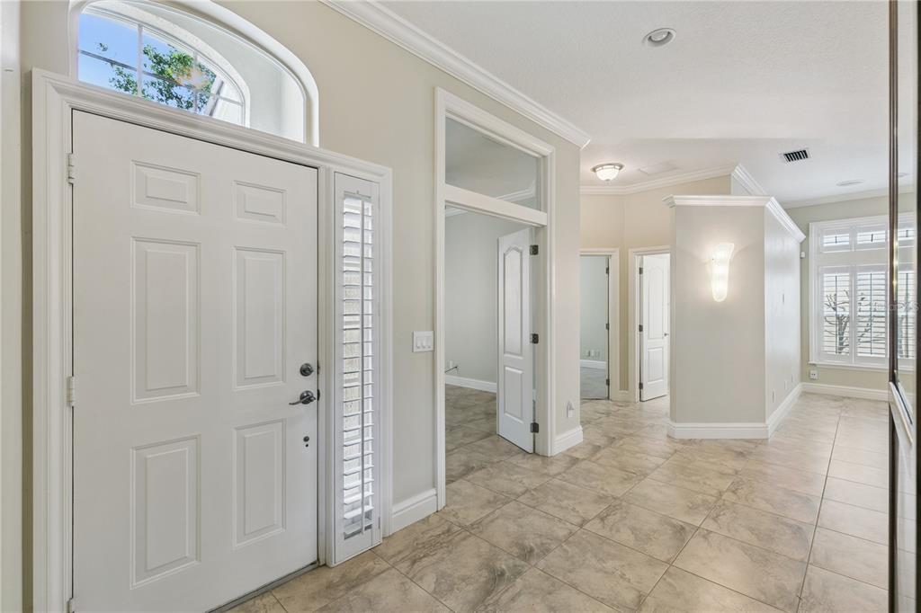 A bright entryway with tile flooring, a white front door, and a transom window — 184 WIMBLEDON CIRCLE, LAKE MARY, FL