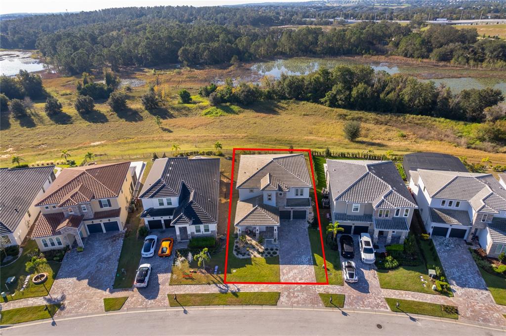 An aerial view shows a two-story house with a tiled roof and paved driveway — 16033 VOLTERRA POINT, BELLA COLLINA, FL