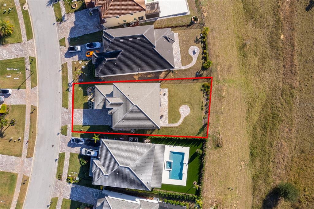 An aerial view shows a single-family home with a fenced backyard and paved driveway — 16033 VOLTERRA POINT, BELLA COLLINA, FL