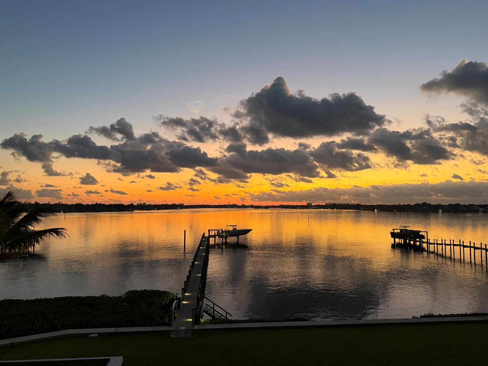 A sunset view over a calm bay with two boat docks and a boat lift — 5211 Pennock Point Road, Jupiter FL 33458, JUPITER, FL
