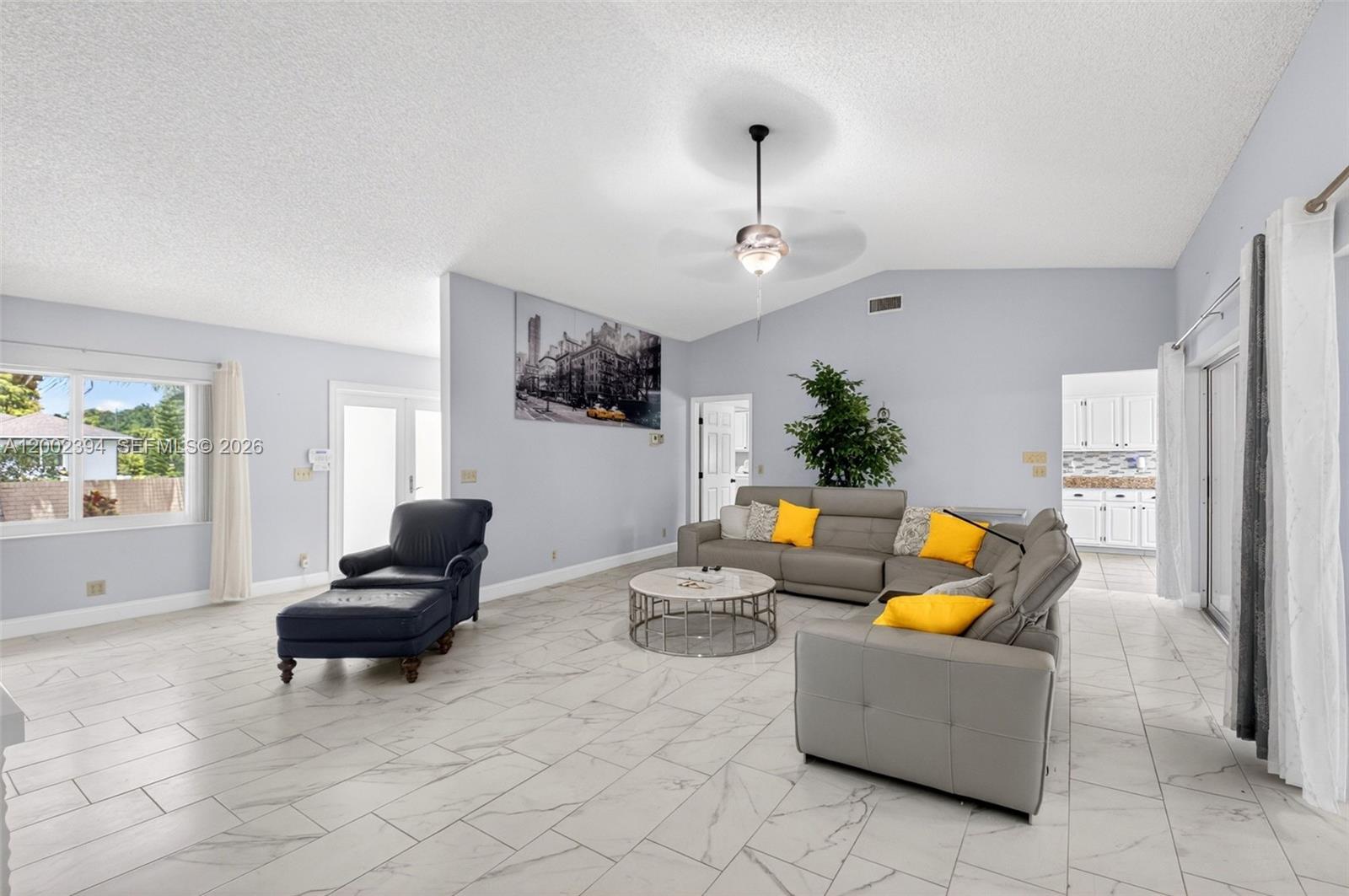 A living room features light gray walls, white marble-look tile flooring, and a gray sectional sofa — 10982 S Greentrail Dr S, Boynton Beach FL 33436, BOYNTON BEACH, FL