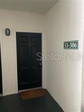 A black front door with a brown welcome mat is labeled with unit number 11-306 — 2549 MAITLAND CROSSING WAY UNIT 306, ORLANDO, FL