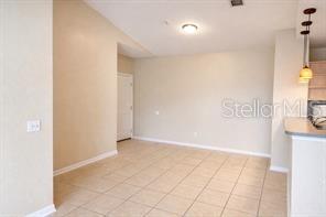 A dining area with beige walls, tile flooring, and a pendant light fixture — 2549 MAITLAND CROSSING WAY UNIT 306, ORLANDO, FL