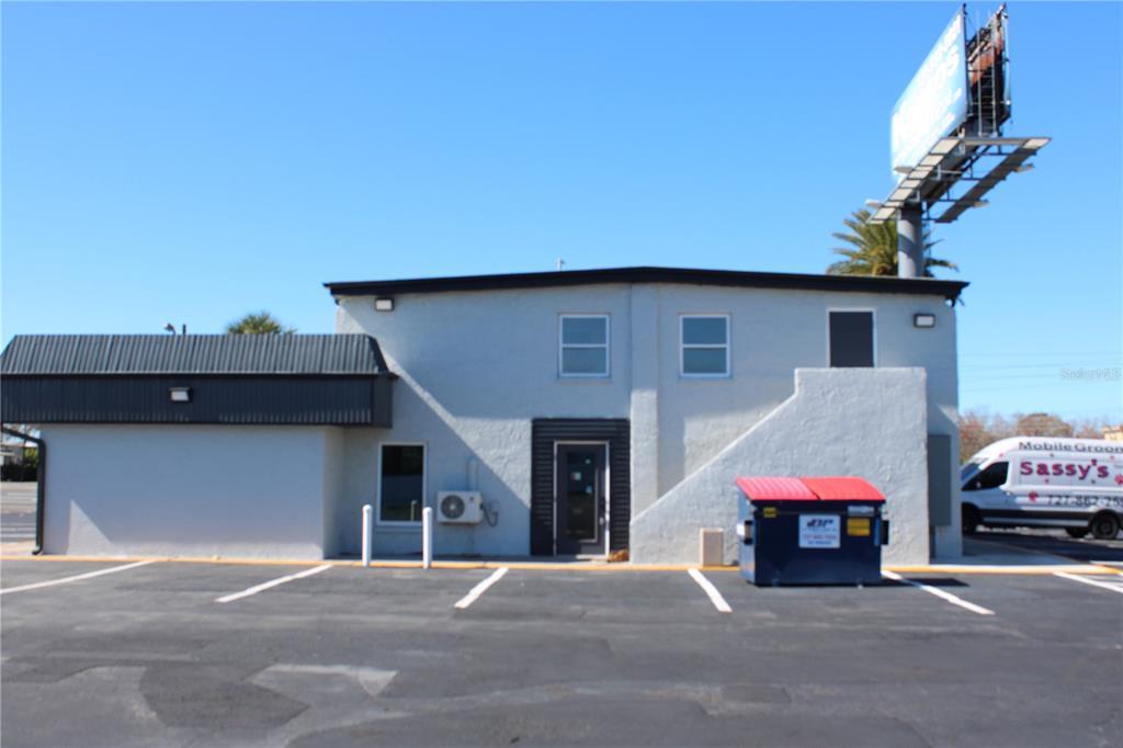 A two-story commercial building with a parking lot, a dumpster, and a mobile grooming van — 1516-1518 US HIGHWAY 19 UNIT D, E, HOLIDAY, FL