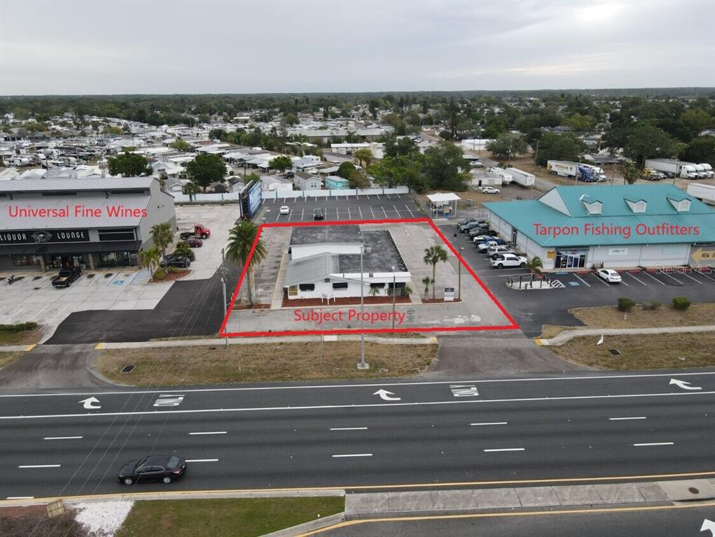 An aerial view shows a commercial building outlined in red between two other businesses — 1516-1518 US HIGHWAY 19 UNIT D, E, HOLIDAY, FL
