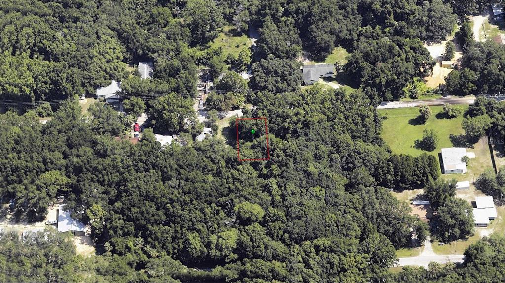 An aerial view shows a rectangular, tree-covered vacant lot outlined in red — 358 NE 13TH TERRACE, CRYSTAL RIVER, FL