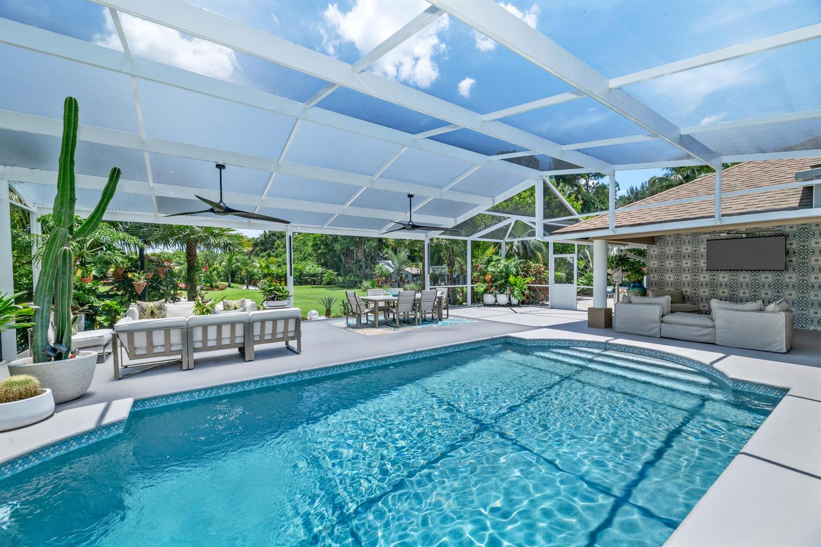 A screened-in patio features a swimming pool, outdoor seating, and a dining area — 14800 April Drive, FL 33470, FL