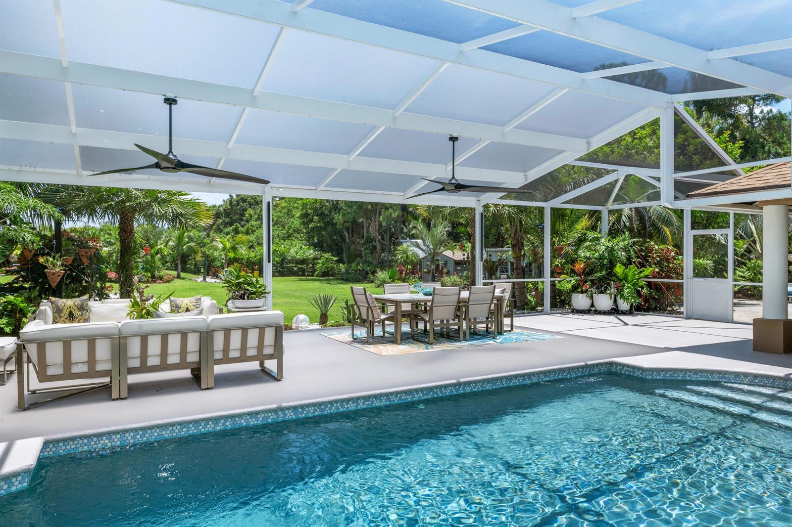 A screened-in patio features a swimming pool, outdoor dining set, and lounge furniture — 14800 April Drive, FL 33470, FL